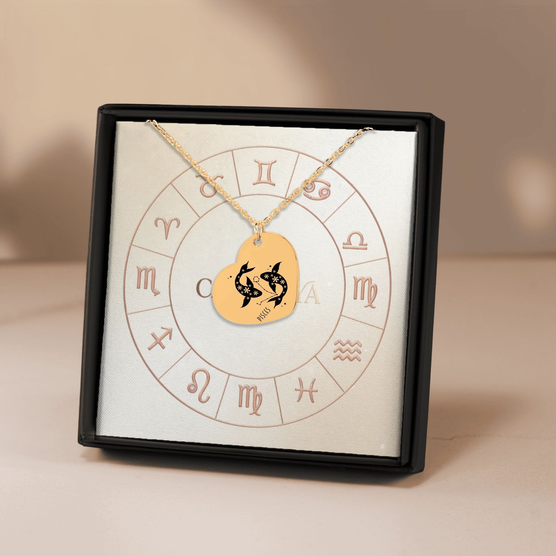 Cardanya gold heart necklace featuring engraved Pisces zodiac sign and floral design, displayed in an astrology-themed gift box.